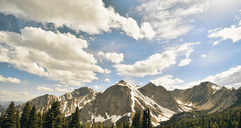 photo of rocky mountains with blue skies and clouds